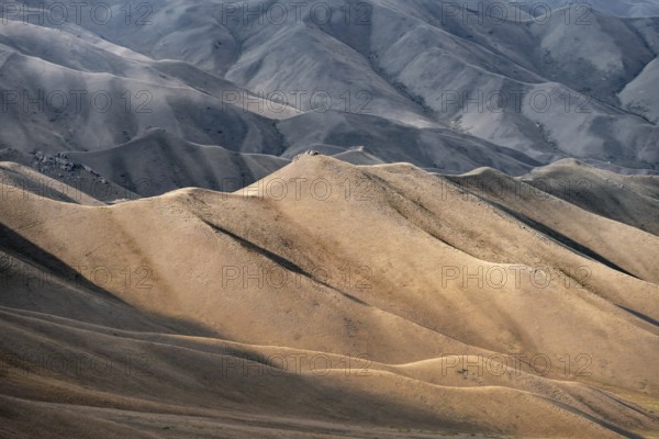 View of mountain landscape with rolling grassy hills at Tyibel Pass, Song Kul Too mountain range, Naryn region, Kyrgyzstan, Asia