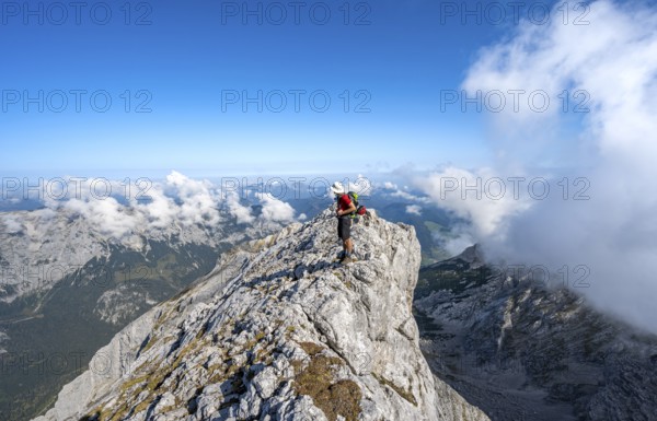Mountaineer on a rocky narrow mountain path with mountain panorama, mountain tour to the summit of the Hochkalter, Hochkalter crossing, Berchtesgaden Alps, Bavaria, Germany, Europe