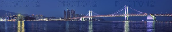 Panorama of Gwangan Bridge and skyscrapers illuminated in the night. Busan, South Korea, Asia