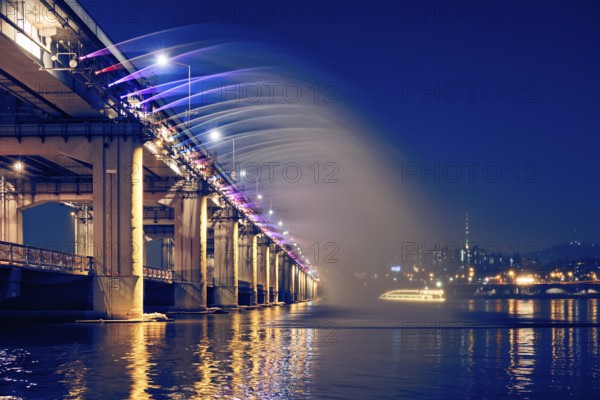 SEOUL, SOUTH KOREA, APRIL 7, 2017: Banpo Bridge Rainbow Fountain tourist landmark on Han river illuminated at night, Seoul, South Korea, Asia