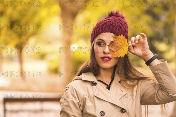 Outdoor atmospheric lifestyle portrait of a beautiful young woman in a forest in autumn at sunset