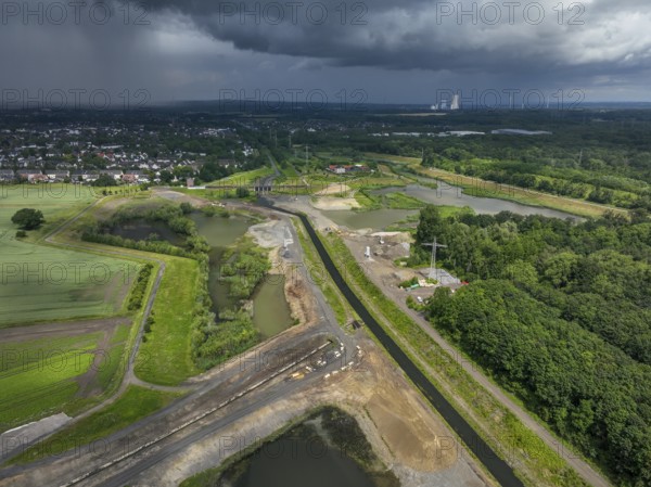 Dortmund / Castrop-Rauxel, North Rhine-Westphalia, Germany, river renaturalisation, renaturation of the Emscher, flood retention basin HRB Mengede. A new floodplain landscape is being created at the Emscher-Auen farm, expanding the area for flood protection during heavy rainfall and for biodiversity. The Emscher, which is currently straightened, will be given curves again and can meander through its new floodplain. Following the construction of a parallel sewer, the Emscher has been completely free of wastewater since 2022. The river was previously an open, above-ground mixed water channel with rainwater and wastewater. At the back right, the Uniper coal-fired power plant Datteln 4 power station, Europe