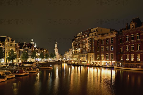 Historic buildings and mint tower illuminated at night, Singelgracht, Amsterdam, North Holland, Netherlands