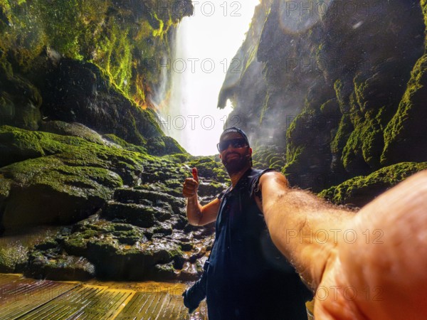 A tourist inside the Iris grotto at the Cola de Caballo Waterfall in the Monasterio de Piedra Natural Park, Aragon