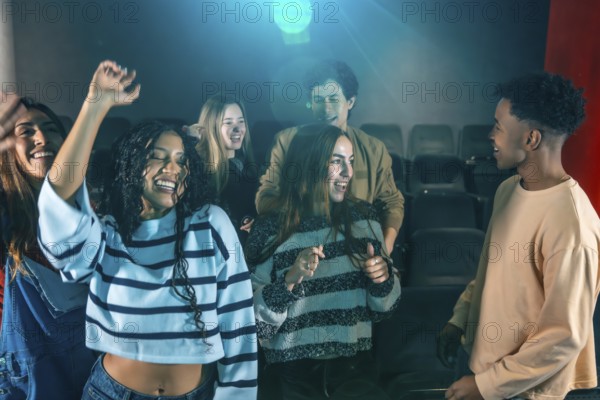 Cheerful young people dancing and having fun at a movie disco event, enjoying music and togetherness in a vibrant cinema atmosphere