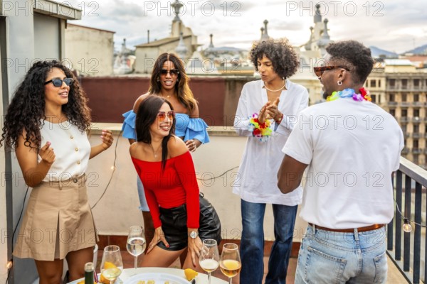 Woman dancing sensually latin music next to multi-ethnic friends in a rooftop party in the evening in the city