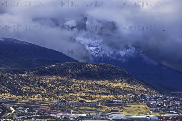 Ushuaia against a magnificent mountain backdrop under a cloudy, mysterious sky, Ushuaia, Argentina, South America