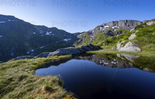 Mountains reflected in a lake, hike to the summit of Rundfjellet, Svolvaer, Nordland, Norway, Europe