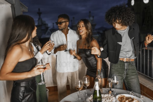 Chic multi-ethnic friends having fun partying in a rooftop at night