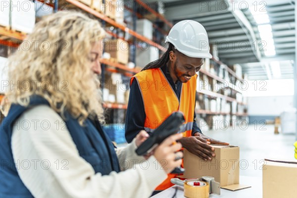 Multiracial female and male manual workers preparing boxes to deliver in a modern warehouse