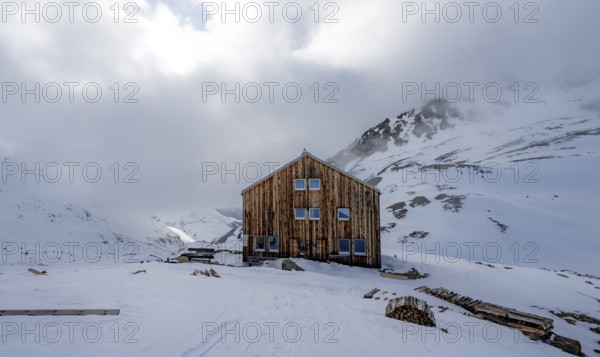 Chamanna Es-cha mountain hut in a wintry, cloudy mountain landscape, Bündner Haute Route ski tour, Albula Alps, Rhaetian Alps, Grisons, Eastern Switzerland, Switzerland, Europe