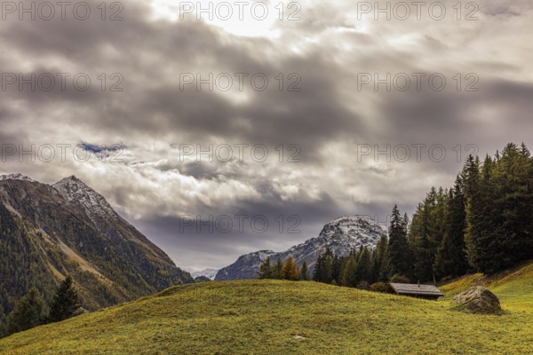 Dark clouds over an alpine meadow above Grimentz, in the background the mountain peaks of Corne de Sorebois and Scex Marenda, Val d'Anniviers, Valais Alps, Canton Valais, Switzerland, Europe