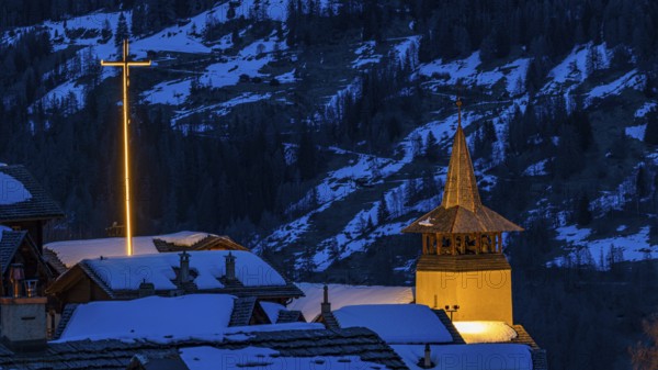 Illuminated Saint Theodule church and illuminated cross in wintery Grimentz, Val d'Anniviers, Valais Alps, Canton Valais, Switzerland, Europe