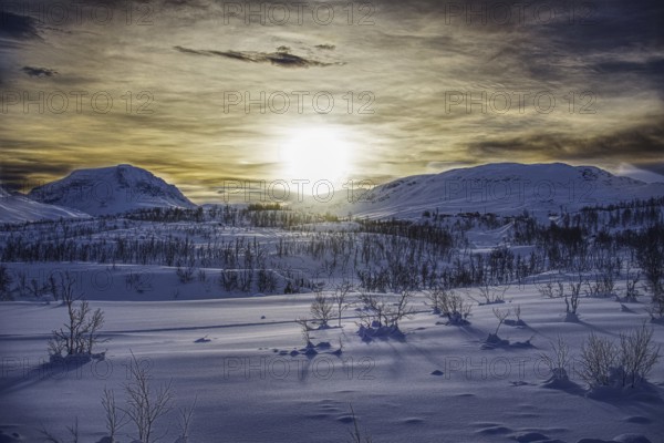 Snowy mountain landscape at sunrise with long shadows, Norway, Europe