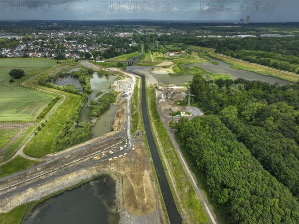 Dortmund / Castrop-Rauxel, North Rhine-Westphalia, Germany, river renaturalisation, renaturation of the Emscher, flood retention basin HRB Mengede. A new floodplain landscape is being created at the Emscher-Auen farm, expanding the area for flood protection during heavy rainfall and for biodiversity. The Emscher, which is currently straightened, will be given curves again and can meander through its new floodplain. Following the construction of a parallel sewer, the Emscher has been completely free of wastewater since 2022. The river was previously an open, above-ground mixed water channel with rainwater and wastewater. At the back right, the Uniper coal-fired power plant Datteln 4 power station, Europe
