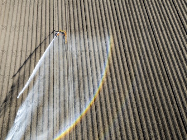 Artificial irrigation of a potato field in April, with a sprinkler system, long drought in spring makes this necessary, for the total of 7.5 hectares 3 full days are needed to get the necessary moisture for the freshly sown potato plants, south of Straelen, Lower Rhine, North Rhine-Westphalia, Germany, Europe