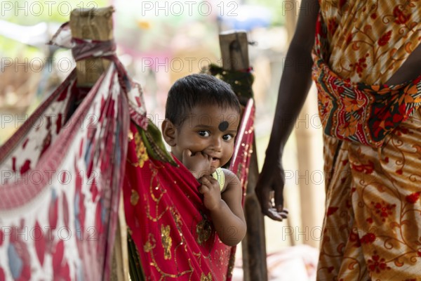 Children of tea plantation workers takes care by daycare worker underneath a tent as their mothers pluck tea leaves at the Tea Estate on April 2, 2025 in Bansbari, Assam, India, Asia