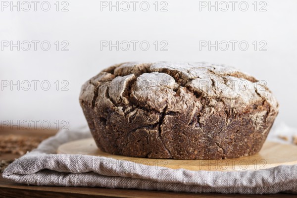 Yeast free homemade bread with whole rye and wheat grains on rustic wooden background. close up