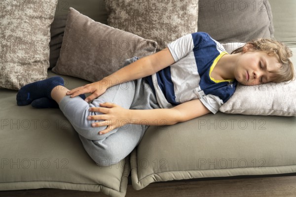 Growing pains in children, boy, 10 years old, has pain in his leg, symbolic picture