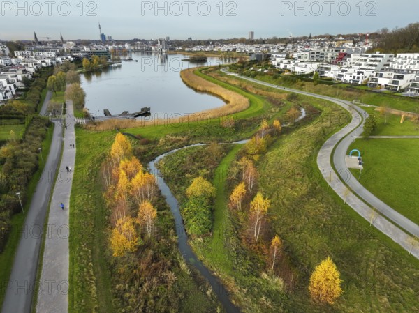 Dortmund, North Rhine-Westphalia, Germany, Phoenix Lake, front of the renaturalised Emscher. The river has been transformed into a near-natural body of water, flood protection and biodiversity through newly designed floodplains. A former industrial wasteland of 99 hectares was transformed into residential, work and leisure areas and 24 hectares of lake surface. In the event of heavy rainfall, the lake acts as a rainwater retention basin. Following the construction of a parallel sewer, the Emscher is now free of wastewater, having previously been an open, above-ground wastewater sewer, combined sewer with surface water and wastewater. The Phoenix Lake, a showcase project for structural change, is an artificial lake on the site of the former Phönix Ost steelworks in Dortmund's Hörde district, Europe