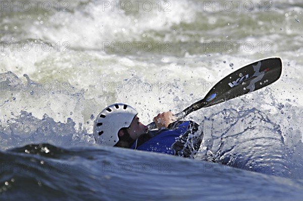 Kayaker kayaking in kayak in white water rapid