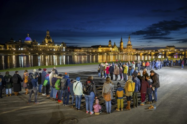 On 13 and 14 February 1945, Dresden was heavily destroyed in three Allied bombing raids. Every year, the people of Dresden commemorate this event at various events. A long human chain symbolised the protection of the city centre. Here looking from the Königsufer across the Elbe to the Old Town, Dresden, Saxony, Germany, Europe