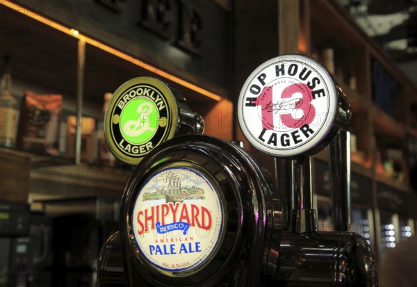 Bar beer signs different beers at Wetherspoons bar, Stansted airport, Essex, England, UK
