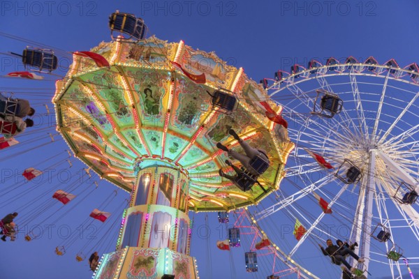 Illuminated carousel and Ferris wheel at night in a lively amusement park, funfair, wave flight, Cannstadter Volksfest, Stuttgart-Bad Cannstsdt, Baden-Württemberg