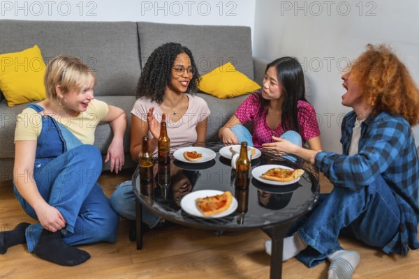 Four diverse friends sitting around a table, laughing and talking while enjoying pizza and drinks at a casual home party