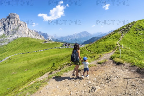 Mother and son enjoying the scenic view of the giau pass in the italian dolomites during a summer hike