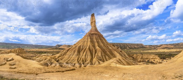 Eroded rock formations standing tall in the bardenas reales desert in navarre, spain, under a dramatic cloudy sky