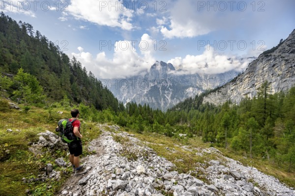 Mountaineer descending via the Ofental valley, mountain peak of the horse-rider Alpe behind, mountain tour on the Hochkalter, Hochkalter crossing, Berchtesgaden Alps, Bavaria, Germany, Europe