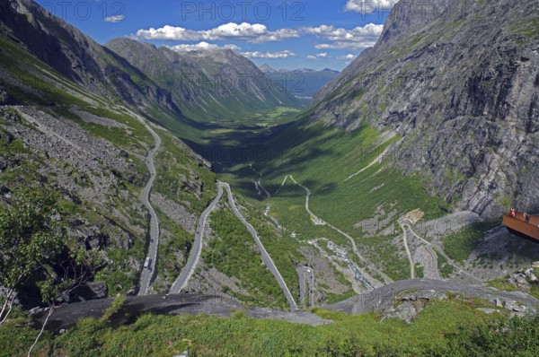 View over a winding mountain road and a narrow valley, rough rocks, small viewing platform, Trollstigen, Norway, Europe