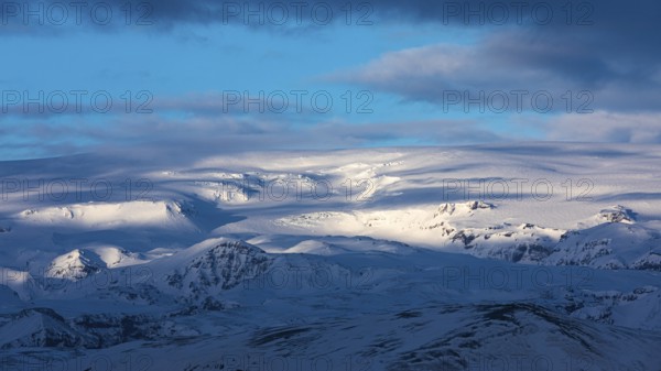 Light and shadow over the snowy hills and mountains of Myrdalsjökull, Sudurland, Iceland, Europe