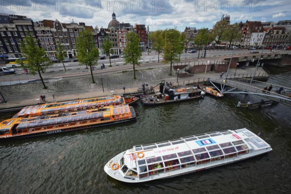 AMSTERDAM, NETHERLANDS, MAY 9, 2017: Aerial view of Amsterdam canal with tourist boats near Amsterdam Centraal