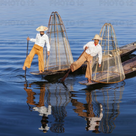 Myanmar travel attraction landmark, Traditional Burmese fishermen with fishing net at Inle lake in Myanmar famous for their distinctive one legged rowing style
