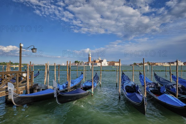 Gondolas and in lagoon of Venice by Saint Mark (San Marco) square with San Giorgio di Maggiore church in background in Venice, Italy, Europe