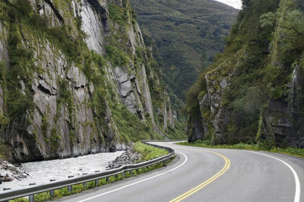 Road leads through a narrow canyon, high cliffs and Chugach Mountains, Thompson Pass, Richardson Highway, Alaska, USA, North America