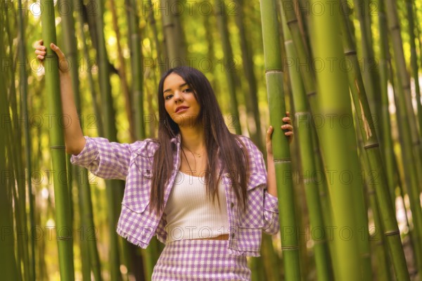 Young caucasian girl with a pink skirt in a bamboo forest. Enjoying the city on summer vacation in a tropical climate, lifestyle of a girl walking through the beautiful forest