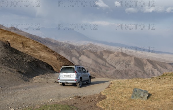 Off-road vehicle at the Tyibel Pass, mountain landscape of the Song Kul Too mountain range, Naryn region, Kyrgyzstan, Asia
