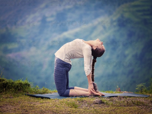 Yoga, outdoors young beautiful slender woman yoga instructor doing camel pose Ustrasana asana exercise outdoors. Vintage retro effect filtered hipster style image