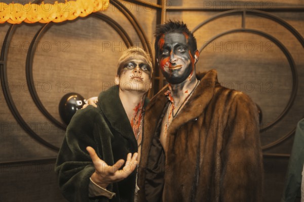 Friends in costumes at the halloween party with friends in a disco nightclub