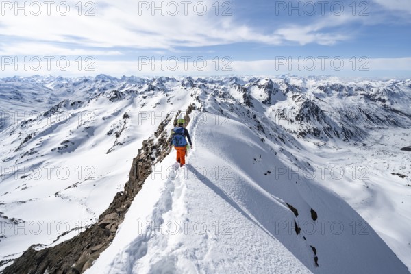 Mountaineer on a narrow mountain ridge in winter, summit of Piz Grialetsch, view of mountain panorama with snow, Grisons Haute Route, Albula Alps, Rhaetian Alps, Grisons, Switzerland, Europe