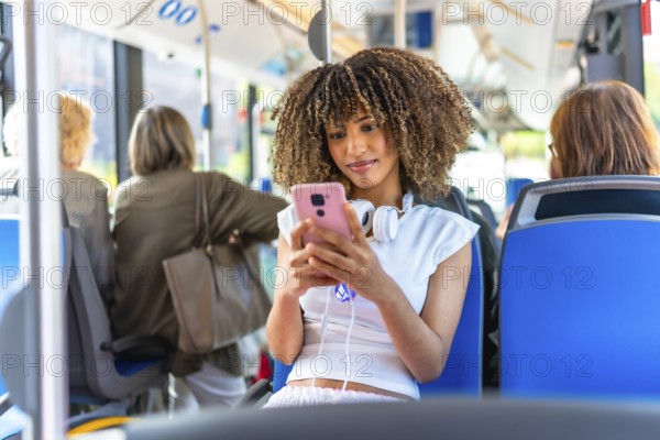 Young beauty latin woman with curly hair and casual clothes using phone distracted sitting on public bus