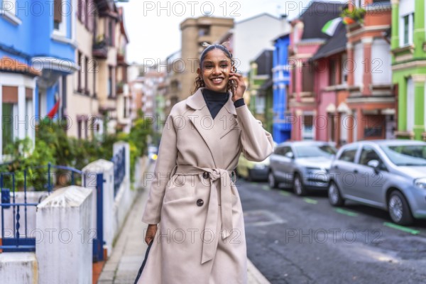 Stylish african american young and beauty woman talking to the mobile phone walking along the city