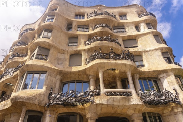Wrought iron balconies and undulating facade of casa mila, a famous modernist building in barcelona, designed by antoni gaudi