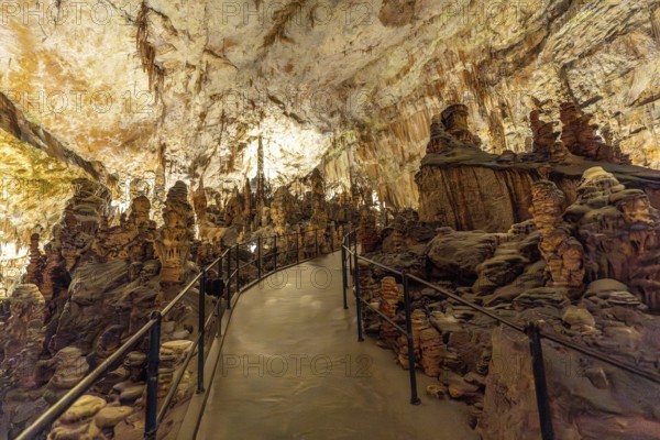 Footpath winding through stunning stalagmite and stalactite formations inside the famous postojna cave in slovenia