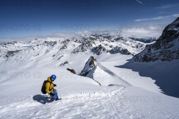 Mountaineer with ice axe and crampons, ascent through steep snowfield to Piz Kesch or Piz d'Es-cha in winter, view of mountain panorama with Vadret da Porchabella glacier, Albula Alps, Rhaetian Alps, Grisons, Eastern Switzerland, Switzerland, Europe