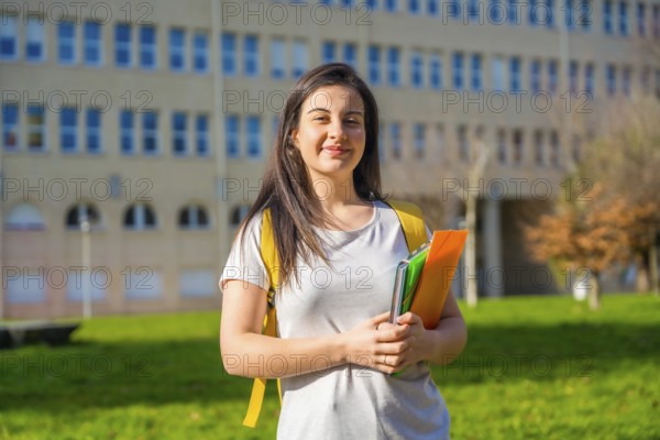 Portrait of beautiful smiling female college student in the campus