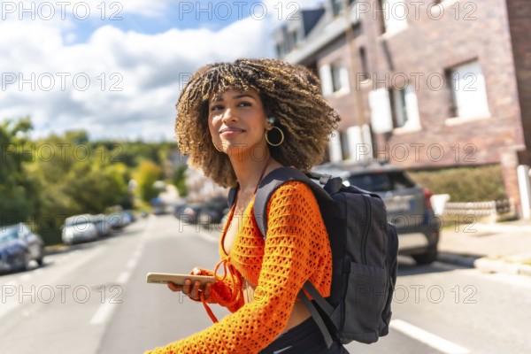 Side view of a beauty latin woman walking along street using mobile phone to get directions with gps